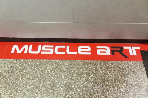 Червената лента с надпис Muscle Art на пода